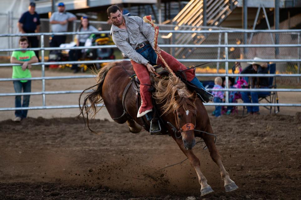 Cowboys compete for a prize pool as they try to stay on a bucking horse Monday, Sept. 19, 2022, at the St. Joseph County Grange Fair in Centreville. 
