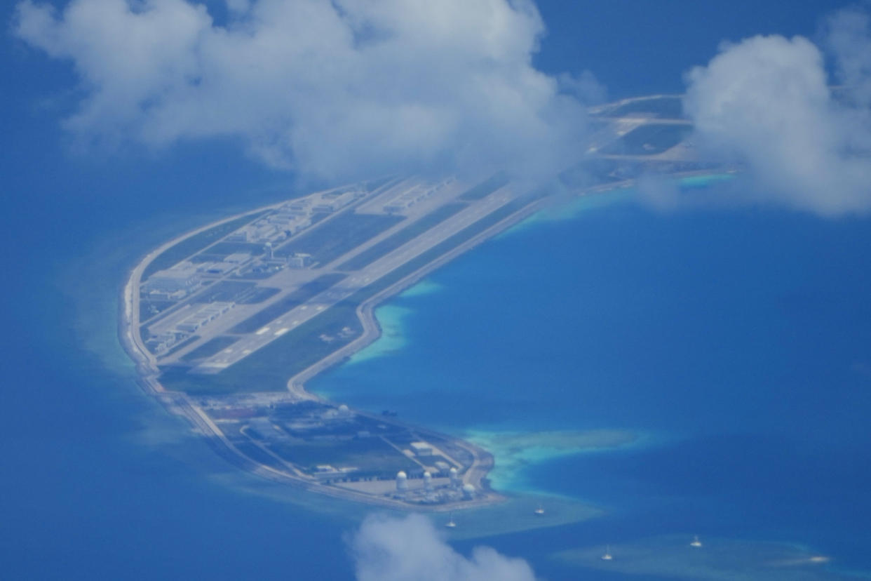 An airstrip made by China is seen beside structures and buildings at the man-made island on Mischief Reef at the Spratlys group of islands in the South China Sea are seen on Sunday March 20, 2022. A U.S. Navy plane carrying a top American military commander was threatened repeatedly by radio on Sunday to leave the airspace over Chinese-occupied island garrisons in the disputed South China Sea, but the aircraft pressed on defiantly with its reconnaissance in brief but tense standoffs witnessed by two Associated Press journalists invited onboard. (AP Photo/Aaron Favila)