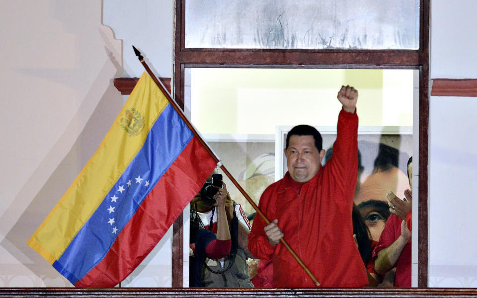 Venezuelan President Hugo Chavez waves a Venezuelan flag while speaking to supporters after receiving news of his reelection in Caracas on October 7, 2012. According to the National Electoral Council, Chavez was reelected with 54.42% of the votes, beating opposition candidate Henrique Capriles, who obtained 44.97%. AFP PHOTO/JUAN BARRETO        (Photo credit should read JUAN BARRETO/AFP/GettyImages)