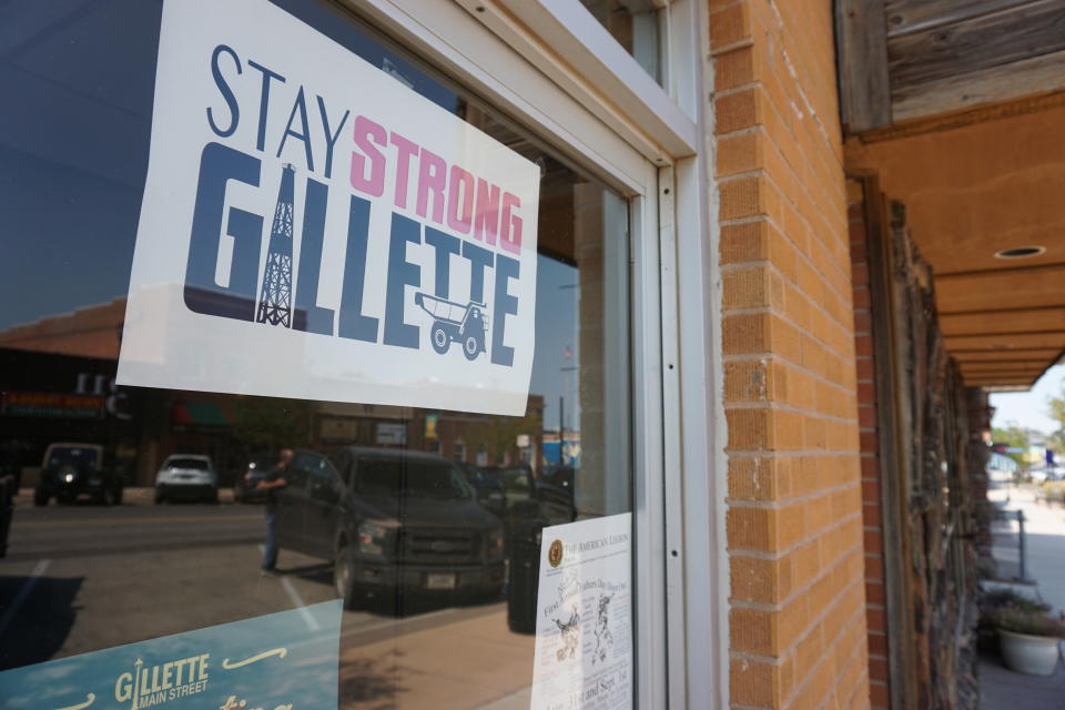In this Thursday, Sept. 5, 2019 photo shows a poster urging locals to stay strong amid hardship in a Gillette, Wyo, storefront on the Eagle Butte mine just north of Gillette, Wyo. The shutdown of Blackjewel LLC's Belle Ayr and Eagle Butte mines in Wyoming since July 1, 2019 has added yet more uncertainty to the Powder River Basin's struggling coal economy. (AP Photo/Mead Gruver)