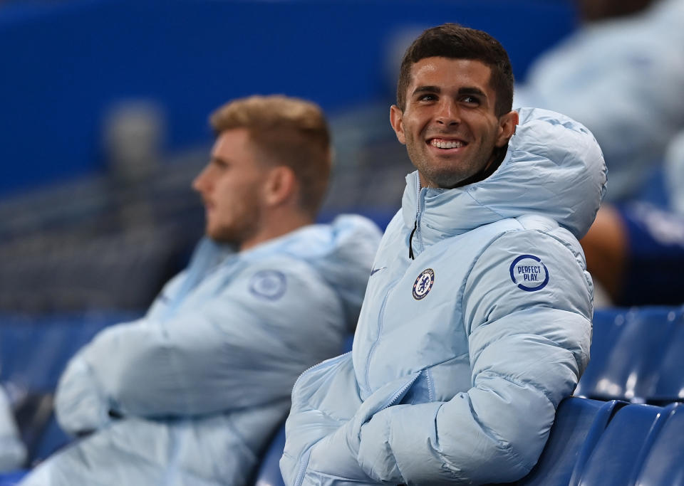 Christian Pulisic looks on and smiles from the stands during the Carabao Cup.