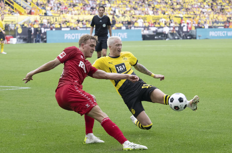 Marco Reus del Borussia Dortmund y Timo Hubers del Colonia pelean port el balón durante el encuentro de la Bundesliga el sábado 19 de agosto del 2023. (Bernd Thissen/dpa via AP)