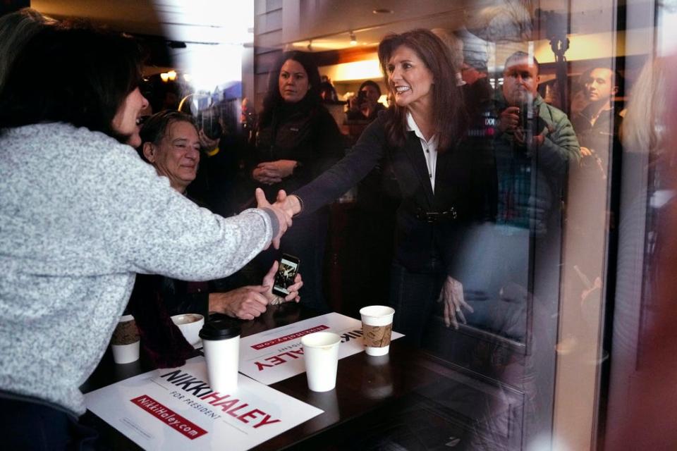 Republican presidential candidate Nikki Haley, seen through a storefront window, shakes hands with guests while visiting Kay's Bakery and Cafe during a campaign stop Jan. 19, 2024, in Hampton, N.H.