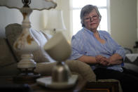 Joyce Loazia interacts with ElliQ, front, a tabletop device that uses artificial intelligence to conduct human-like conversations, during an interview in her apartment in a senior community in Coral Springs, Fla., Tuesday, Dec. 5, 2023. Loazia is among the first in the country to receive the robot ElliQ, whose creators, Intuition Robotics, and senior assistance officials say is the only device using artificial intelligence specifically designed to lessen the loneliness and isolation experienced by many older Americans. (AP Photo/Rebecca Blackwell)