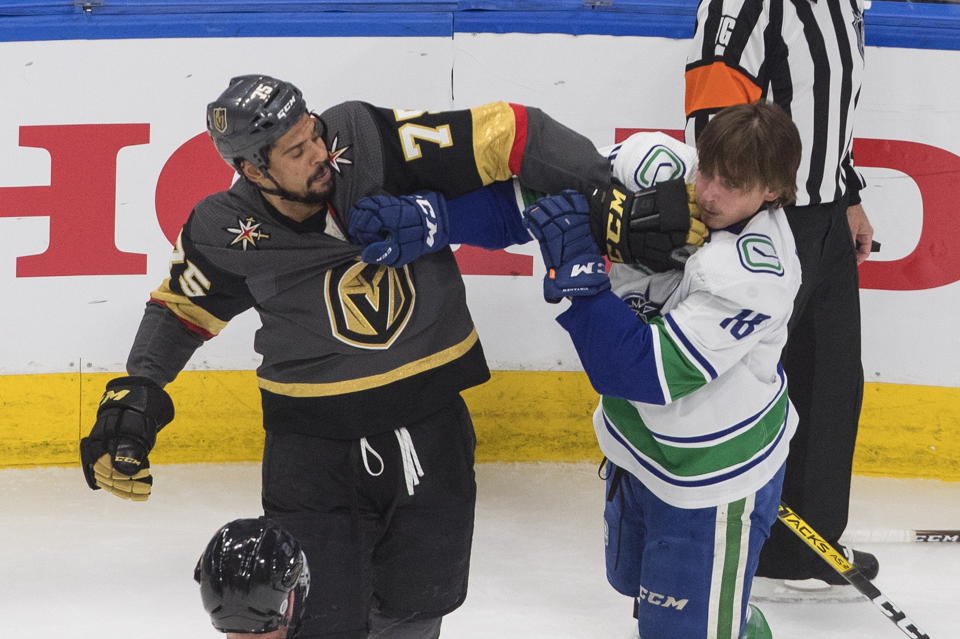 Vancouver Canucks' Jake Virtanen (18) and Vegas Golden Knights' Ryan Reaves (75) rough it up during the first period of Game 7 of an NHL hockey second-round playoff series, Friday, Sept. 4, 2020, in Edmonton, Alberta. (Jason Franson/The Canadian Press via AP)