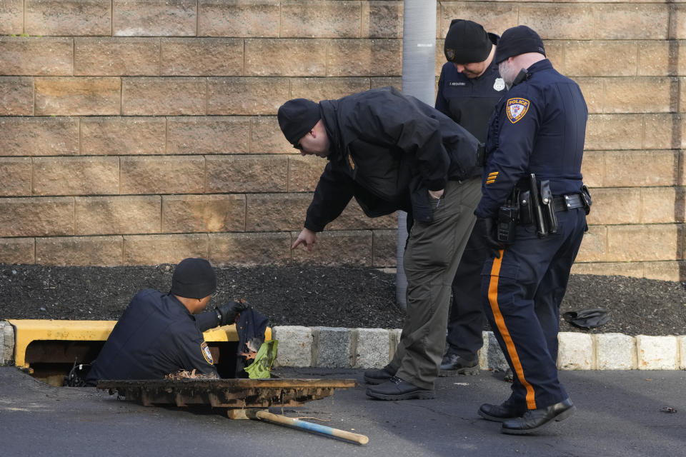 Police search inside a drainage grate near the home of Sayreville councilwoman Eunice Dwumfour in the Parlin area of Sayreville, N.J., Thursday, Feb. 2, 2023. Dwumfour was found shot to death in an SUV parked outside her home on Wednesday. According to the Middlesex County prosecutor's office, she had been shot multiple times and was pronounced dead at the scene. (AP Photo/Seth Wenig)