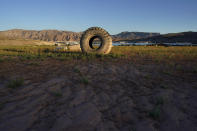 A truck tire once in the water as part of a marina sits on dry ground as water levels have dropped near the Callville Bay Resort & Marina in the Lake Mead National Recreation Area, Tuesday, Aug. 30, 2022, near Boulder City, Nev. Negotiations over the Colorado River have become increasingly difficult for the seven states that rely on the shrinking river and its reservoirs, including Lake Mead, which is dropping to critically low levels. (AP Photo/John Locher)