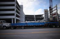 DORAL, FL - OCTOBER 10: A construction worker looks on from a flat bed truck as Miami-Dade Fire Rescue search and rescue workers search in the rubble of a four-story parking garage that was under construction and collapsed at the Miami Dade College’s West Campus on October 10, 2012 in Doral, Florida. Early reports indicate that one person was killed, at least seven people injured and one is still trapped. (Photo by Joe Raedle/Getty Images)