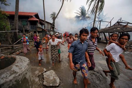 FILE PHOTO: Rohingyas run away from a fire that was set to a part of Sittwe, during clashes June 10, 2012. REUTERS/Soe Zeya Tun/File Photo