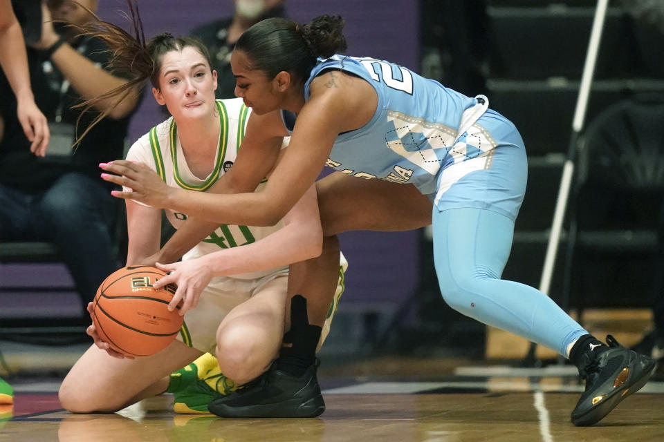 Oregon forward Grace VanSlooten (40) and North Carolina guard Deja Kelly, right, battle for a loose ball during the first half of an NCAA college basketball game at the Phil Knight Invitational tournament Thursday, Nov. 24, 2022, in Portland, Ore. (AP Photo/Rick Bowmer)