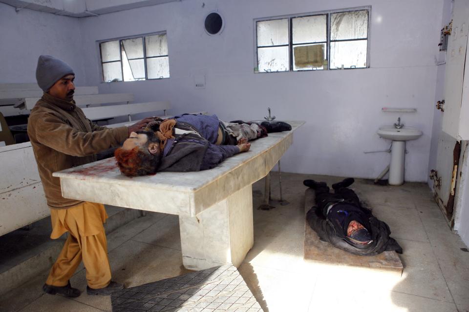 A man identifies the body of a man, who was killed in a bomb attack, at a hospital in Rawalpindi