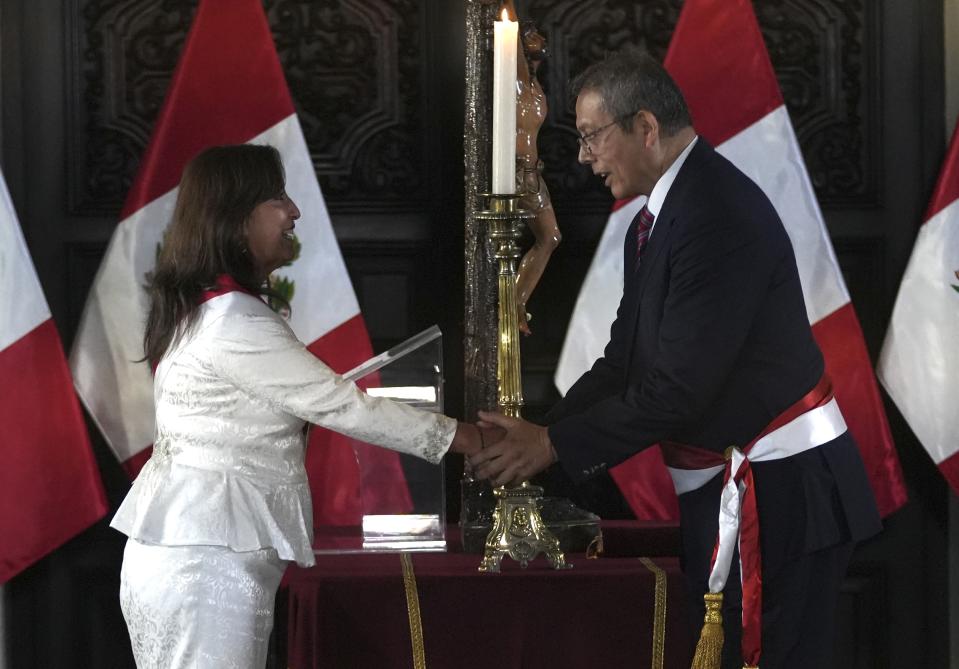 Peru's President Dina Boluarte shakes hands with her Chief of Staff Pedro Angulo during a swearing-in ceremony for her cabinet members, at the government palace in Lima, Peru, Saturday, Dec. 10, 2022. . (AP Photo/Guadalupe Pardo)