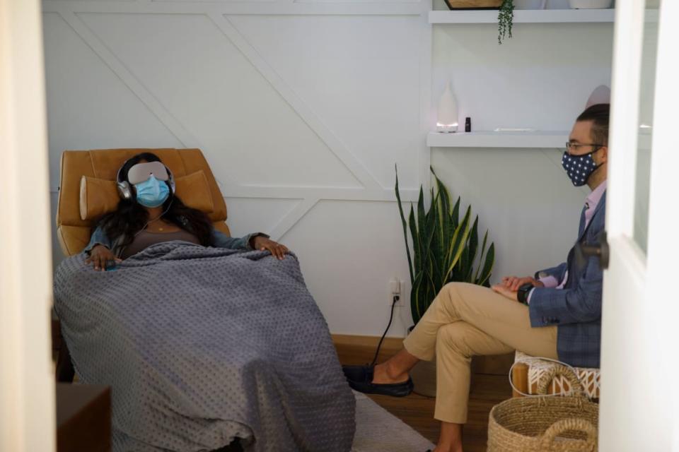 <div class="inline-image__caption"><p>A woman demonstrates what a patient would experience in a therapy room at Field Trip, a psychedelic therapy clinic in as medical director Dr. Michael Verbora waits by her side in Toronto, Ontario, Canada, on Aug. 28, 2020. </p></div> <div class="inline-image__credit">Cole Burston/AFP via Getty</div>