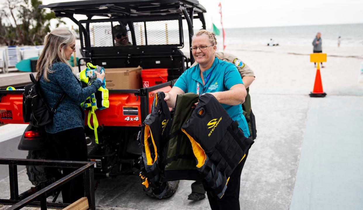 Tina Fleming, A child advocate at Golisano ChildrenÕs Hospital unloads life jackets to be placed in a life jacket loser stations built by Gateway High Schools students on Thursday, Jan. 4, 2024. The stand was built by the students at Gateway High School in partnership with Lee Health and others. Tina Fleming, a child advocate at Golisano Children's Hospital secured grants to get six stands built. Two are already placed. The stations offer life jackets to those who need them while visiting area beaches. Several Life jacket stands were lost in Hurricane Ian.