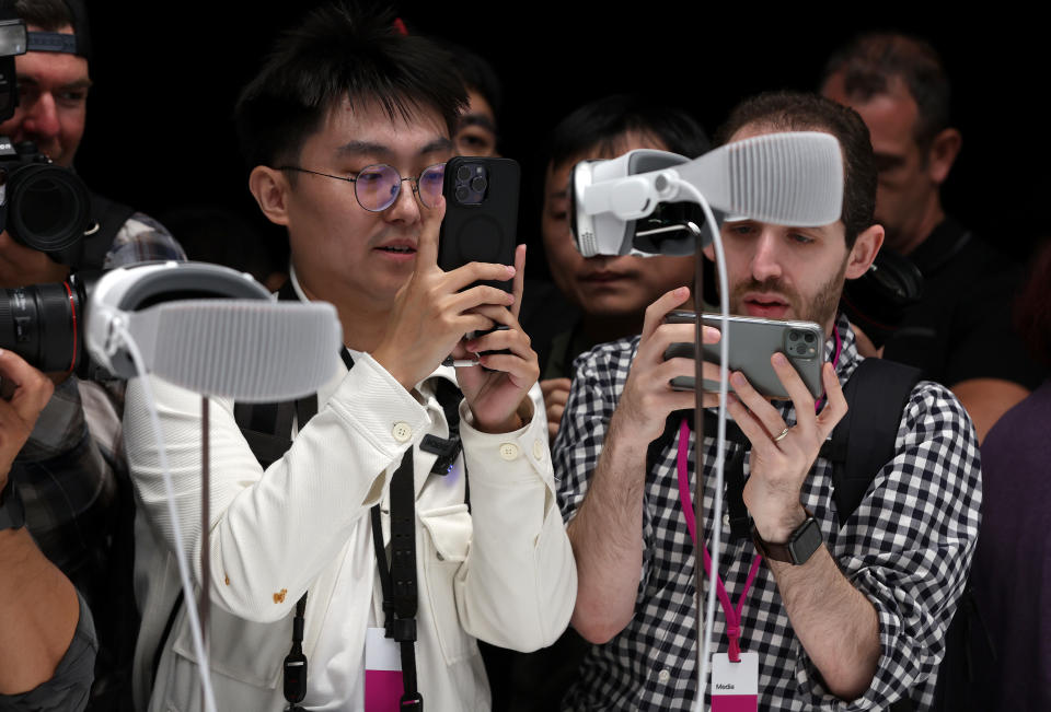 Members of the media inspect iPhones at an Apple conference. (Photo by Justin Sullivan/Getty)