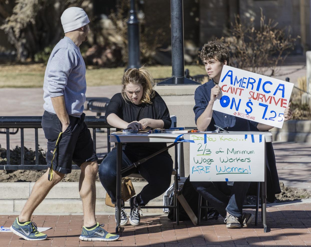 Boulder, Colorado, USA - February 19, 2014: Two young people in downtown Boulder explain why Americans can't survive on $7.25 minimum wager per hour.