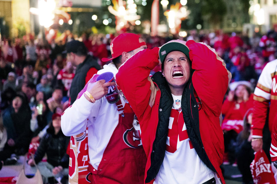 A San Francisco 49ers fan reacts while watching a telecast of NFL football's Super Bowl 58 on a screen outside the Chase Center in San Francisco on Sunday, Feb. 11, 2024. (AP Photo/Noah Berger)