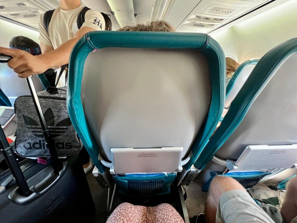 View of the back of the seat in front of the writer on the plane