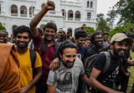 Protesters cheer as they leave prime minister Ranil Wickremesinghe's office building in Colombo, Sri Lanka, Thursday, July 14, 2022. Sri Lankan protesters began to retreat from government buildings they seized and military troops reinforced security at the Parliament on Thursday, establishing a tenuous calm in a country in both economic meltdown and political limbo. (AP Photo/Rafiq Maqbool)