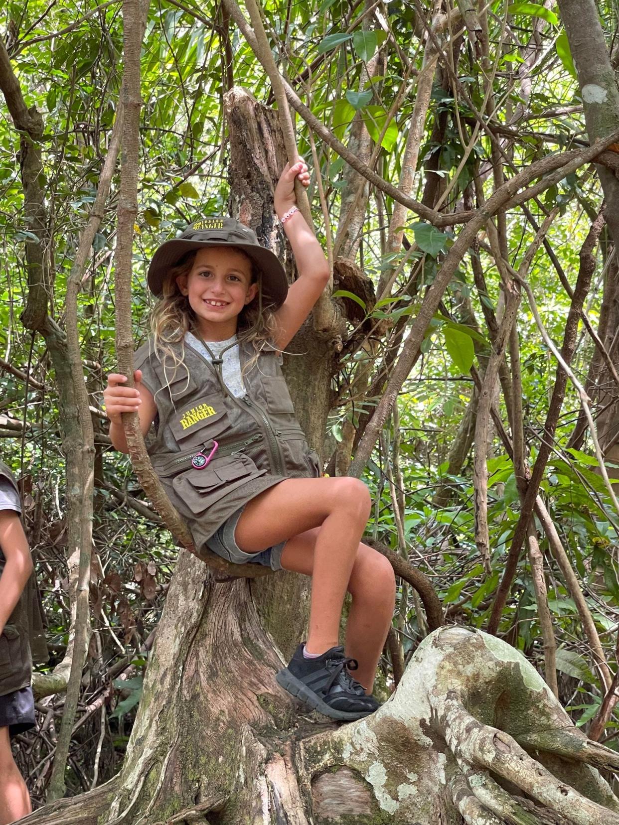 Maya Zrihen proudly wears her Junior Ranger hat, vest and badges all around.