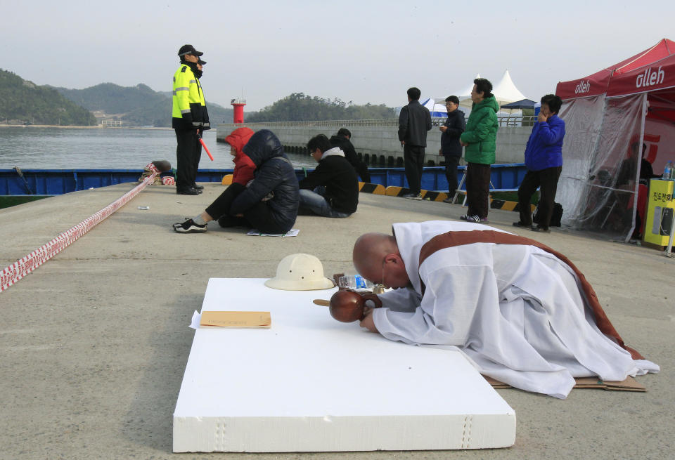 A Buddhist monks prays for the safe return of passengers of the sunken Sewol ferry at a port in Jindo, South Korea, Tuesday, April 22, 2014. As divers continue to search the interior of the sunken ferry, the number of confirmed deaths has risen, with about 220 other people still missing. (AP Photo/Ahn Young-joon)