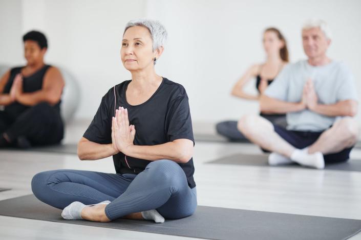 Mindfulness is an important part of yoga practice and has been linked to many health benefits. <a href="https://www.gettyimages.com/detail/photo/mature-woman-doing-yoga-in-class-royalty-free-image/1349259739?phrase=yoga%20sitting%20group&adppopup=true" rel="nofollow noopener" target="_blank" data-ylk="slk:SeventyFour/iStock via Getty Images" class="link ">SeventyFour/iStock via Getty Images</a>