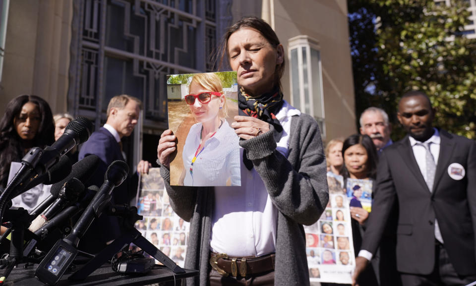 Catherine Berthet, of France, closes her eyes as he holds a photo of her deceased daughter Camille Geoffroy, in front of other families that lost loved ones to crashes of the Boeing 737 Max airliner outside the federal court in Fort Worth, Texas, Thursday, Jan. 26, 2023.(AP Photo/LM Otero)