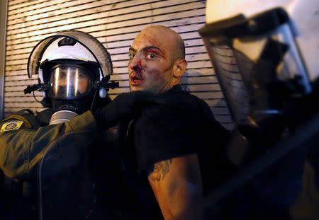 A protester bleeds as he is arrested by riot police following clashes in Athens, Greece in this July 15, 2015 file photo. REUTERS/Yannis Behrakis/Files