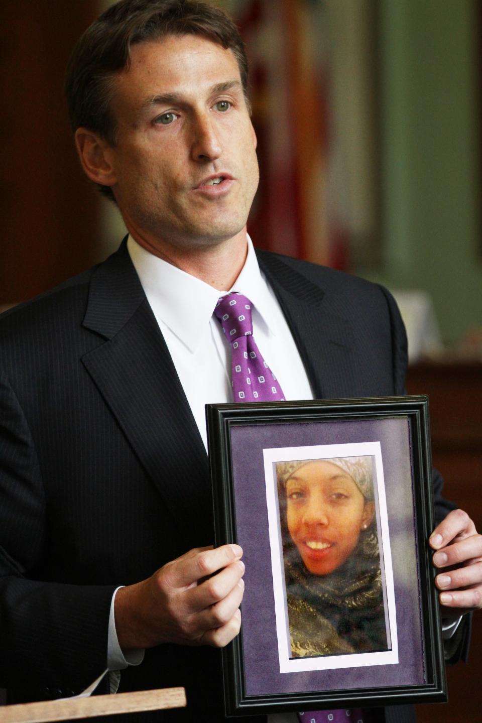 Assistant Attorney General James Baum holds a photo of murder victim Shameeka Barros during opening statements in the 2014 trial of  Quandell Husband.