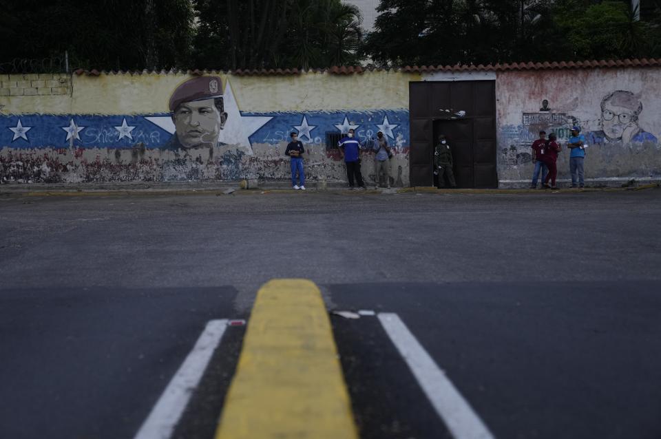 A mural with the image of late Venezuela president Hugo Chavez stands outside of a voting center in Caracas, Venezuela, Sunday, Nov 21, 2021. Venezuelans are going to the polls to elect state governors and other local officials. (AP Photo/Ariana Cubillos)