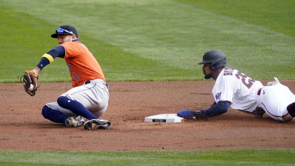 Minnesota Twins' Byron Buxton, right, steals second base as Houston Astros shortstop Carlos Correa takes the throw in the first inning of an American League wild-card series baseball game Tuesday, Sept 29, 2020, in Minneapolis. (AP Photo/Jim Mone)