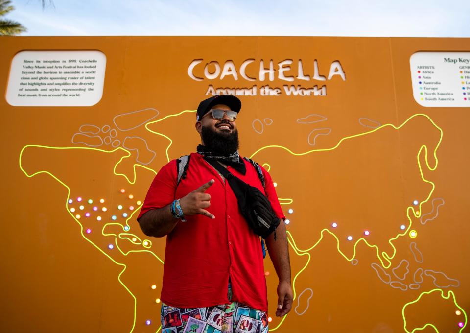 Angel Chavez of Coachella poses for a photo in front of the Coachella around the world map on the festival grounds during the Coachella Valley Music and Arts Festival at the Empire Polo Club in Indio, Calif., Saturday, April 22, 2023. 