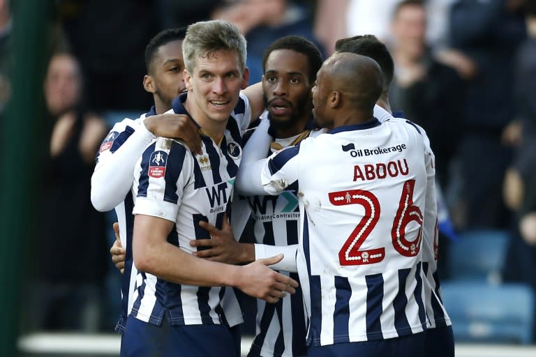 Millwall's Shaun Cummings (C) celebrates with teammates after scoring the only goal of their English FA Cup fifth round football match against Leicester City in south London on February 18, 2017