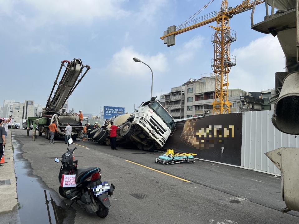 台中市沙鹿區錦華街一處建案外，因地面塌陷造成一部預拌混凝土車側翻，司機受困車內，獲救後送醫。（中央社／民眾提供）