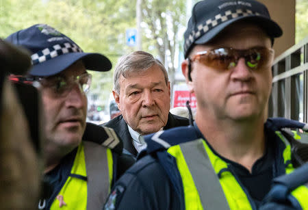 Vatican Treasurer Cardinal George Pell walks towards the Melbourne Magistrates Court with Australian police in Australia, October 6, 2017. REUTERS/Mark Dadswell - RC1F7DB52C90