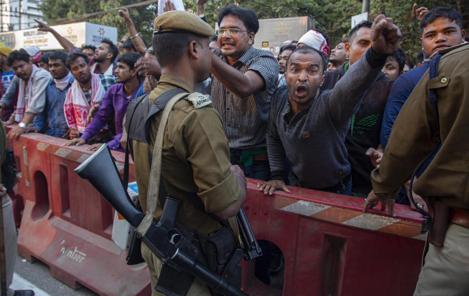 Protesters shout slogans against the Citizenship Amendment Bill (CAB) in Gauhati, India, Wednesday, Dec. 11, 2019. Protesters burned tires and blocked highways and rail tracks in India's remote northeast for a second day Wednesday as the upper house of Parliament began debating legislation that would grant citizenship to persecuted Hindus and other religious minorities from Pakistan, Bangladesh and Afghanistan. (AP Photo/Anupam Nath)