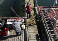 FOTO DE ARCHIVO: Chris Keegan habla con su amigo Ryan Whelan, mientras filetea un róbalo rayado pescado fuera de la casa de Keegan, en el vecindario de Broad Channel de Queens, en la ciudad de Nueva York, EEUU, el 2 de noviembre de 2019