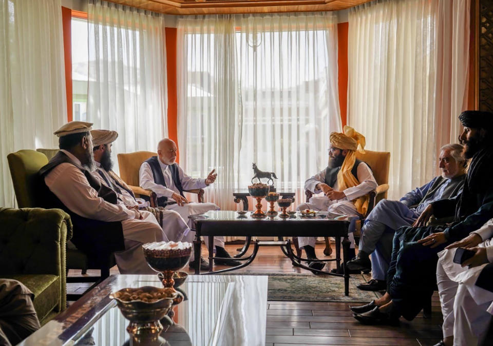 In this handout photograph released by the Taliban, former Afghan President Hamid Karzai, center left, senior Haqqani group leader Anas Haqqani, center right, Abdullah Abdullah, second right, head of Afghanistan's National Reconciliation Council and former government negotiator with the Taliban, and others in the Taliban delegation, meet in Kabul, Afghanistan, Wednesday, Aug. 18, 2021. The meeting comes after the Taliban's lightning offensive saw the militants seize the capital, Kabul. (Taliban via AP)