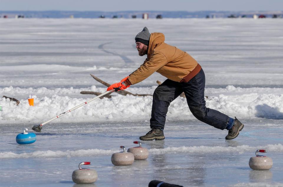 Jacob Tripp of Rosendale pushes a stone during the Fond du Lac Outdoor Funspiel Feb. 12, 2022, during the Sturgeon Spectacular at Lakeside Park.