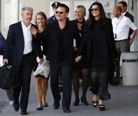 Irish singer Bono, lead singer of group U2, and his wife Ali Hewson arrive to take a taxi boat transporting guests for the wedding of U.S. actor George Clooney and his fiancee Amal Alamuddin, in Venice September 27, 2014. REUTERS/Stefano Rellandini