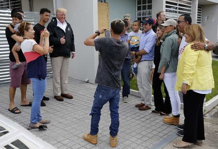 U.S. President Donald Trump poses for a photo with residents while visiting Puerto Rico to survey relief efforts following Hurricane Maria in Guaynabo, Puerto Rico, U.S., October 3, 2017 REUTERS/Jonathan Ernst