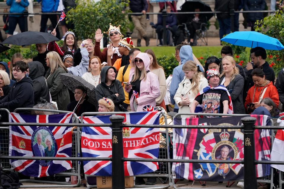 Royal fans gather wearing coats and holding umbrellas (Copyright 2024 The Associated Press. All rights reserved)