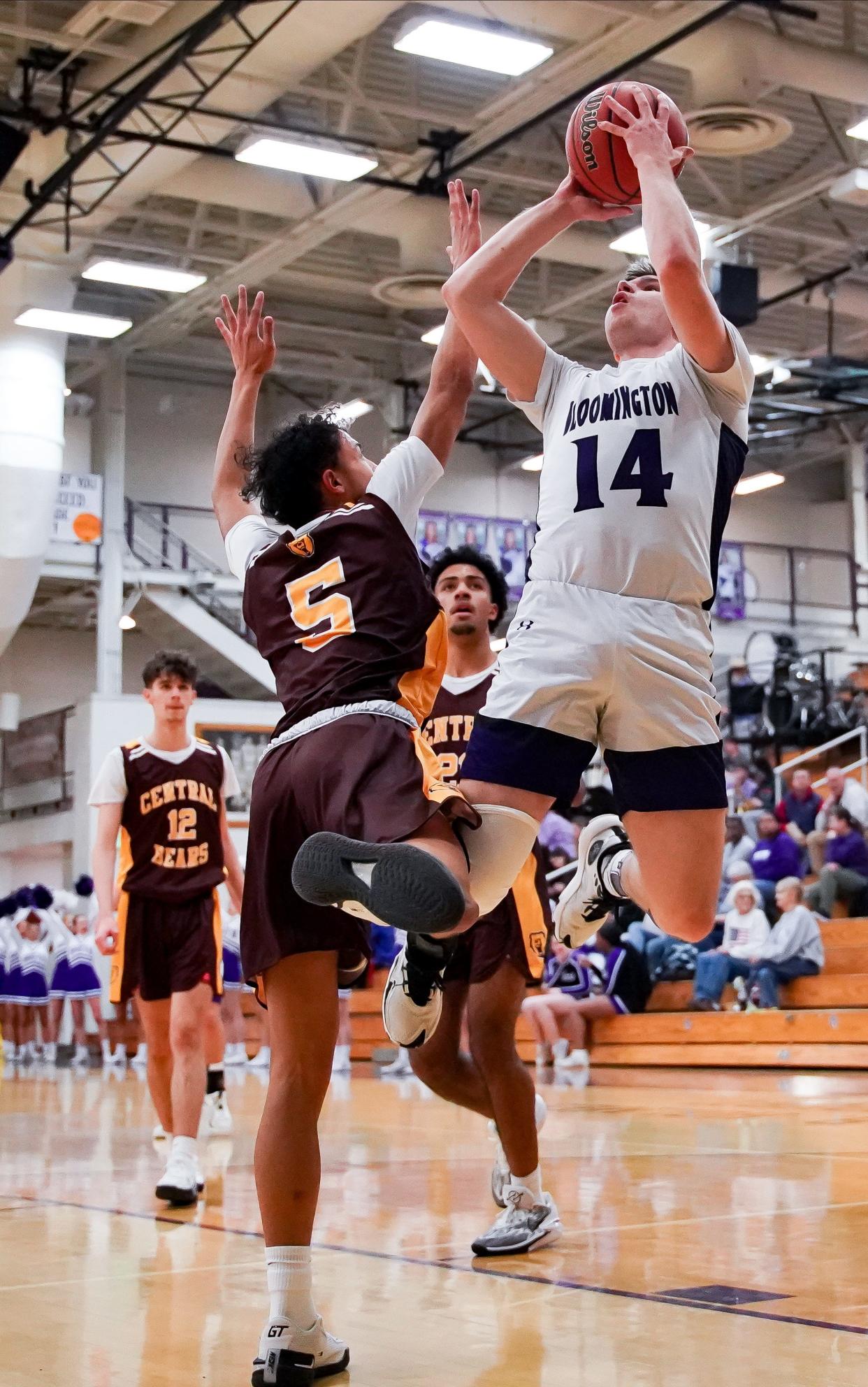 Bloomington South’s Zach Sims (14) scores against Evansville Central’s Zaryen Moore and is fouled during their game at South on Monday, Feb. 19, 2024.