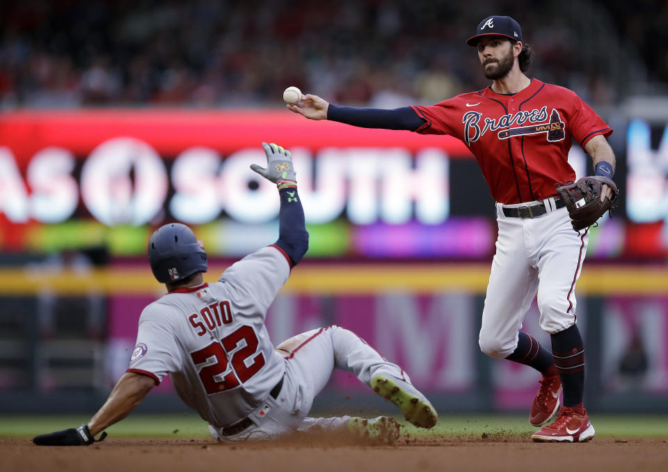 Atlanta Braves' Dansby Swanson, right, throws over Washington Nationals' Juan Soto (22) to complete a double play in the first inning of a baseball game Friday, July 8, 2022, in Atlanta. Josh Bell was out at first base. (AP Photo/Ben Margot)