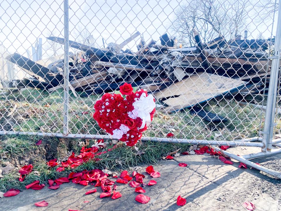 Roses were places on a fence surrounding rubble of a house at 1322 Tatum Street in West Deptford Friday, the site of an explosion and intense house fire that killed a 54-year-old woman, seriously injured a 57-year-old man, and injured several others, Jan. 14, 2022.