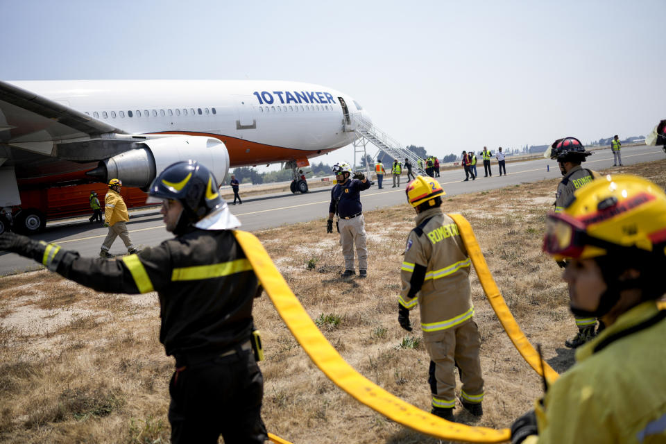 Los bomberos cargan agua en el avión cisterna 10 en el aeropuerto mientras luchan contra los incendios forestales, en Talcahuano, Chile, el lunes 6 de febrero de 2023. Los incendios forestales se están extendiendo en el sur y el centro de Chile, provocando evacuaciones y la declaración de un estado de emergencia en algunas regiones. (Foto AP/Matías Delacroix)