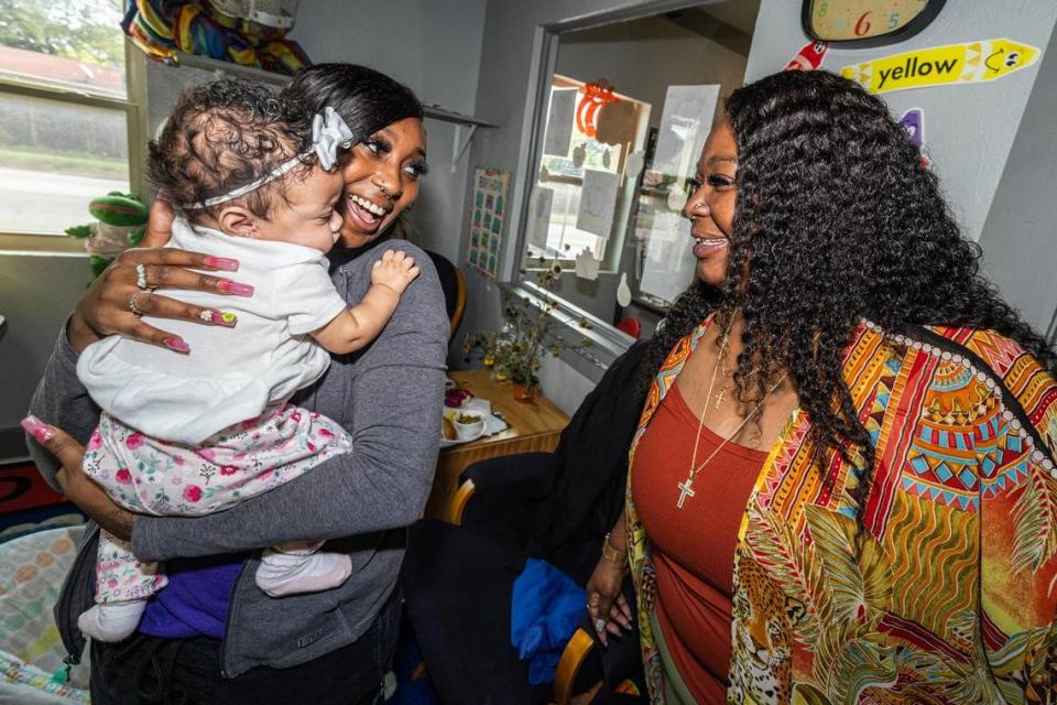 Infant teacher A’Aliyah Rhodes holds Jaela Bouck, 3 months, while Angela James, the operator of Sunrise Early Learning and Development Center, smiles at her at the school in Fort Worth on Thursday, Oct. 26, 2023.