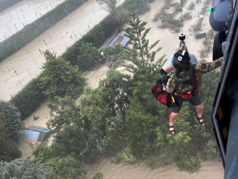 Stranded people being air lifted from their rooftop by a military helicopter in the Esk Valley (New Zealand Defence Force/AFP)