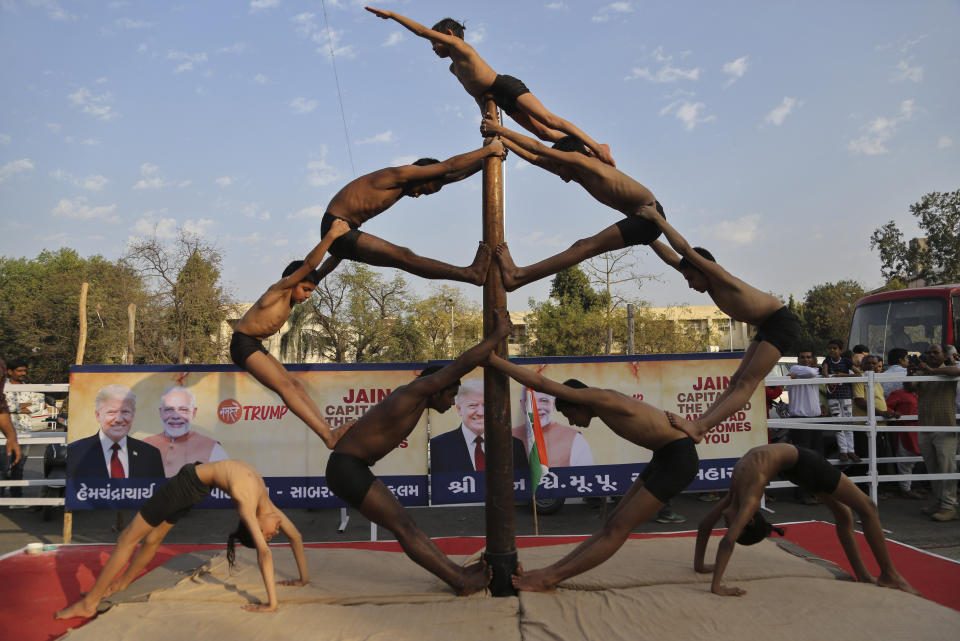 Indian children perform Mallakhamb, a traditional training exercise for wrestlers along a route U.S. President Donald Trump is expected to take during his visit in Ahmedabad, India, Sunday, Feb. 23, 2020. The sun-baked northwestern Indian city was jostling with activity Sunday as workers cleaned roads, planted flowers and hoisted hundreds of billboards featuring President Donald Trump, a day ahead of his maiden two-day visit to India after Prime Minister Narendra Modi promised him a boisterous public reception. (AP Photo/Aijaz Rahi)