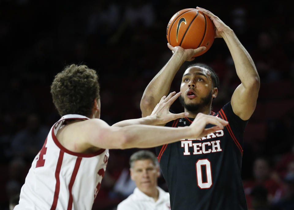 Texas Tech forward Kevin Obanor (0) shoots against Oklahoma forward Jacob Groves during the first half of an NCAA college basketball game Feb. 9, 2022, in Norman, Okla. Texas Tech returners from last season include Obanor, who had double-doubles in each of the Red Raiders’ three NCAA Tournament games as they made another NCAA Sweet 16. 600 words, photos. (AP Photo/Garett Fisbeck, File)